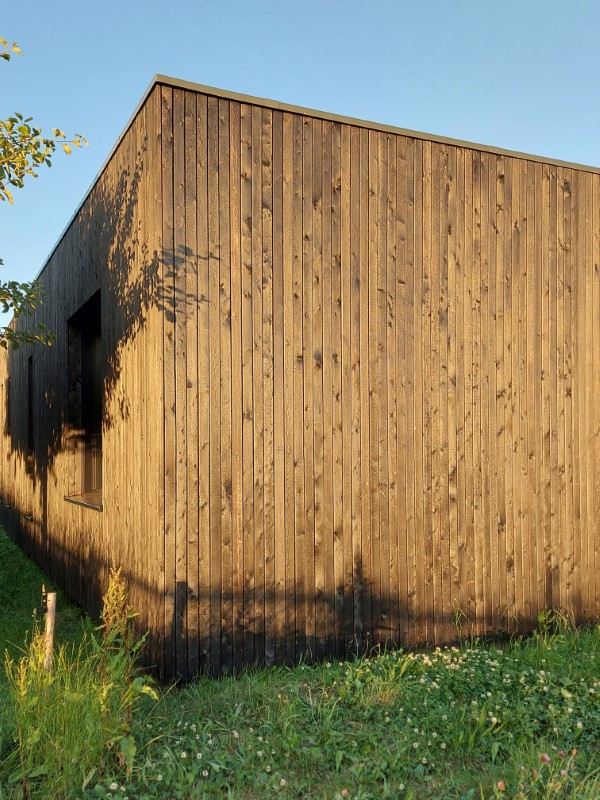 Abendsonne auf einer schwarzen Holzfassade. Neubau Einfamilienhaus Gelnhausen MKK