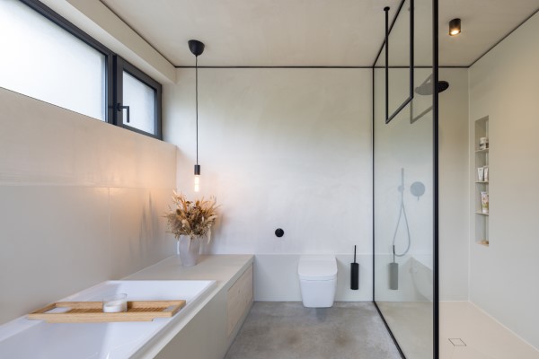 Minimalismus im Badezimmer durch reduzierte Farben und Materialien sowie stimmungsvolle Ambientebeleuchtung