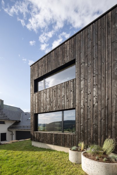 Schwarze Holzfassade eines neugebauten Einfamilienwohnhauses in Schöllkrippen bei Aschaffenburg im bayerischen Spessart
